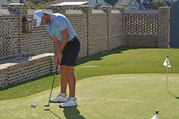 Charlotte Golfer putting on synthetic grass